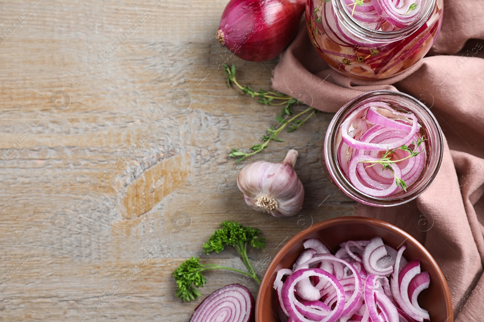 Flat lay composition with jars of pickled onions on wooden table. Space for text Photo of Flat lay composition with jars of pickled onions on wooden table. Space for text