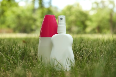 Photo of Bottles of insect repellent on green grass