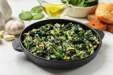 Photo of Tasty spinach dip with eggs in dish served on white table, closeup
