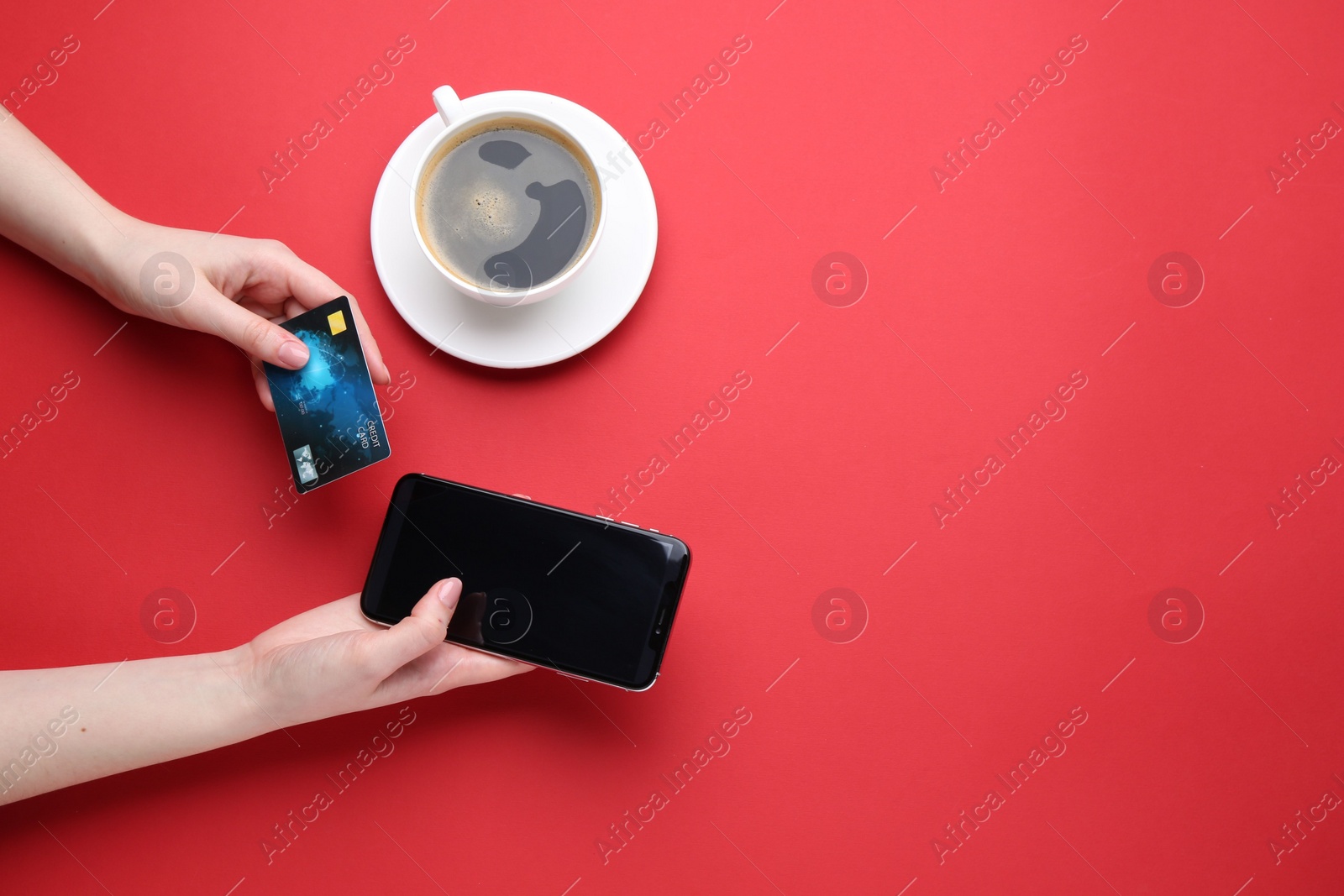 Photo of Online payment. Woman with smartphone, credit card and coffee on red background, top view. Space for text