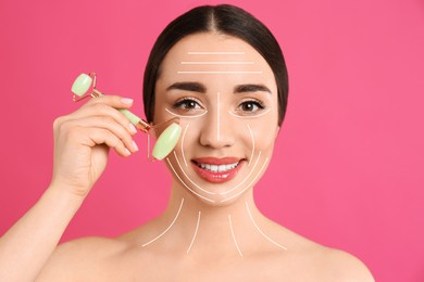 Image of Woman using natural jade face roller on pink background