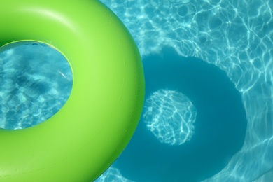 Photo of Bright inflatable ring floating in swimming pool on sunny day. Space for text