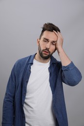 Photo of Man suffering from headache on grey background. Cold symptoms