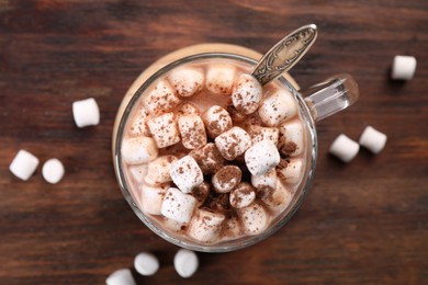 Photo of Cup of aromatic hot chocolate with marshmallows and cocoa powder on wooden table, top view