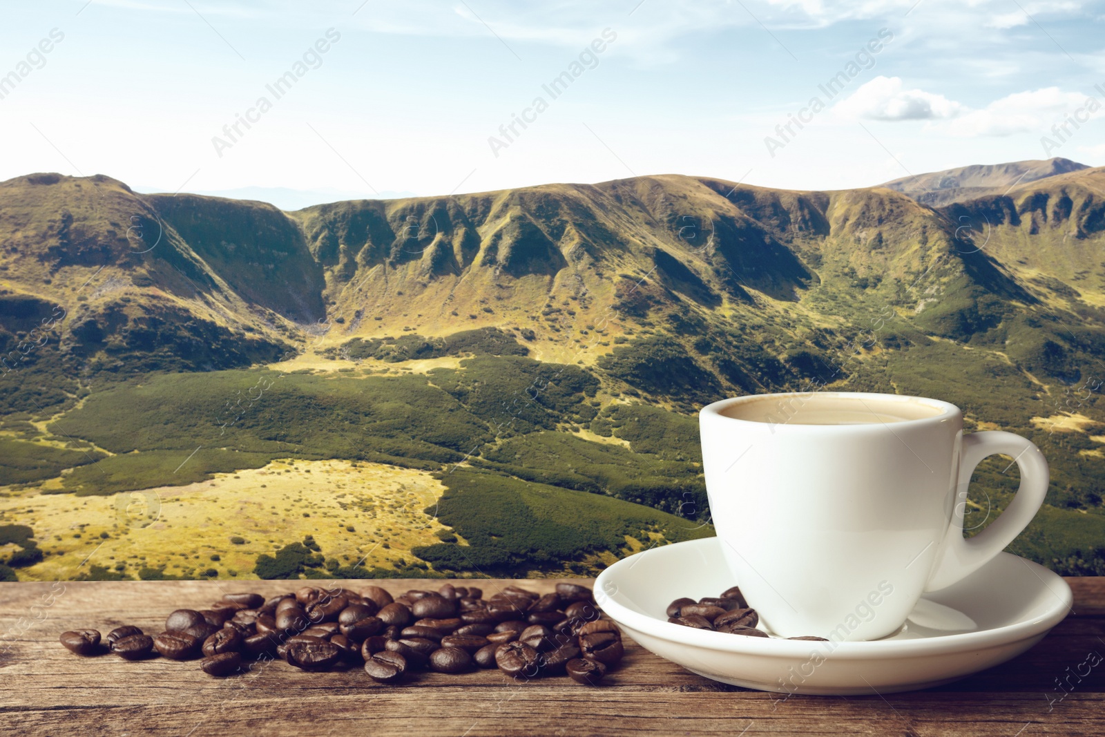 Image of Cup of aromatic hot coffee on wooden table and beautiful view of mountain landscape. Space for text