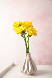 Photo of Bouquet of spring freesia flowers in vase on color background