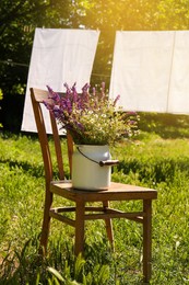 Photo of Beautiful bouquet with field flowers on chair outdoors, space for text