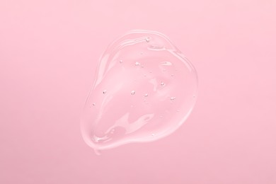 Sample of cleansing gel on light pink background, top view. Cosmetic product