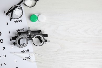 Different ophthalmologist tools on white wooden background, flat lay. Space for text