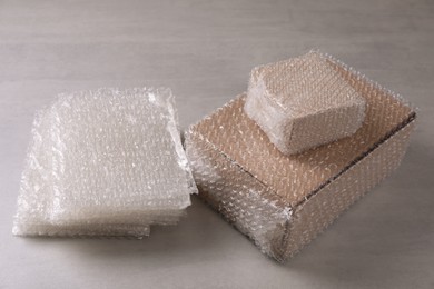 Cardboard boxes and bubble wrap on light grey table