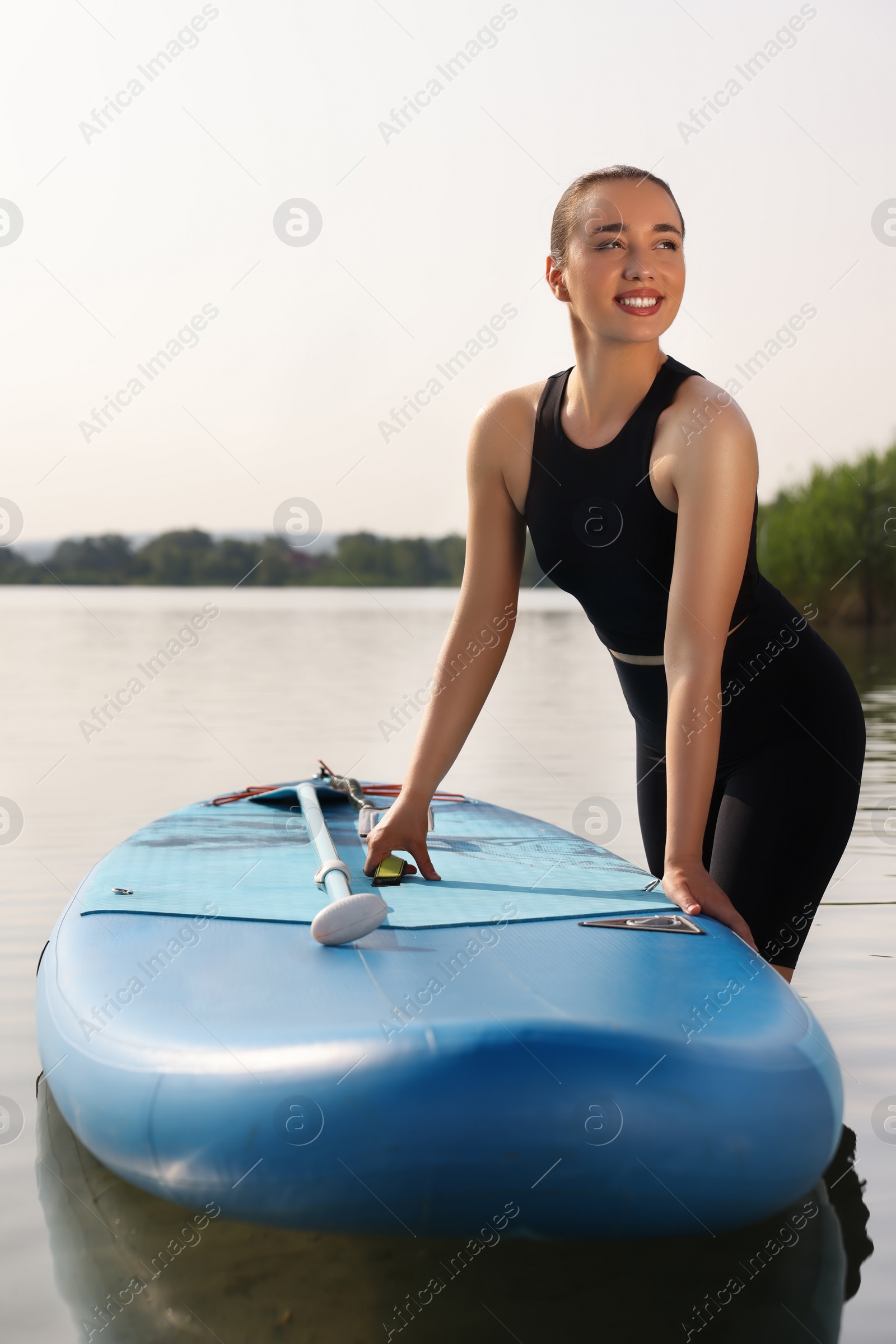 Photo of Woman standing near SUP board in water