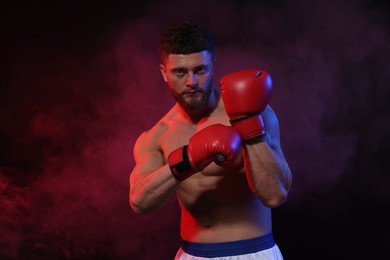 Photo of Man wearing boxing gloves on dark background