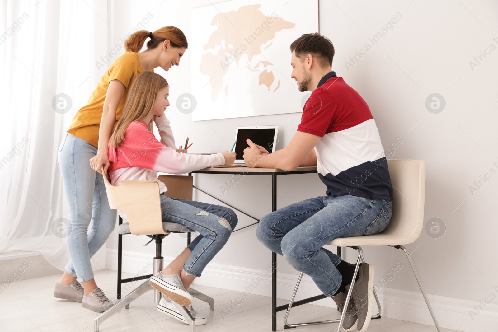 Photo of Parents helping their teenager daughter with homework indoors