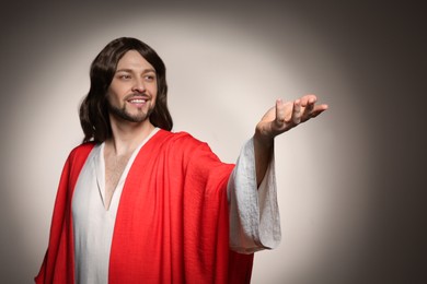 Photo of Jesus Christ reaching out his hand on beige background