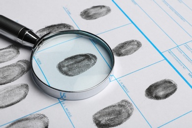 Magnifying glass and criminal fingerprint card, closeup