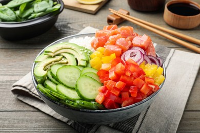 Photo of Delicious poke bowl with salmon and vegetables served on wooden table, closeup