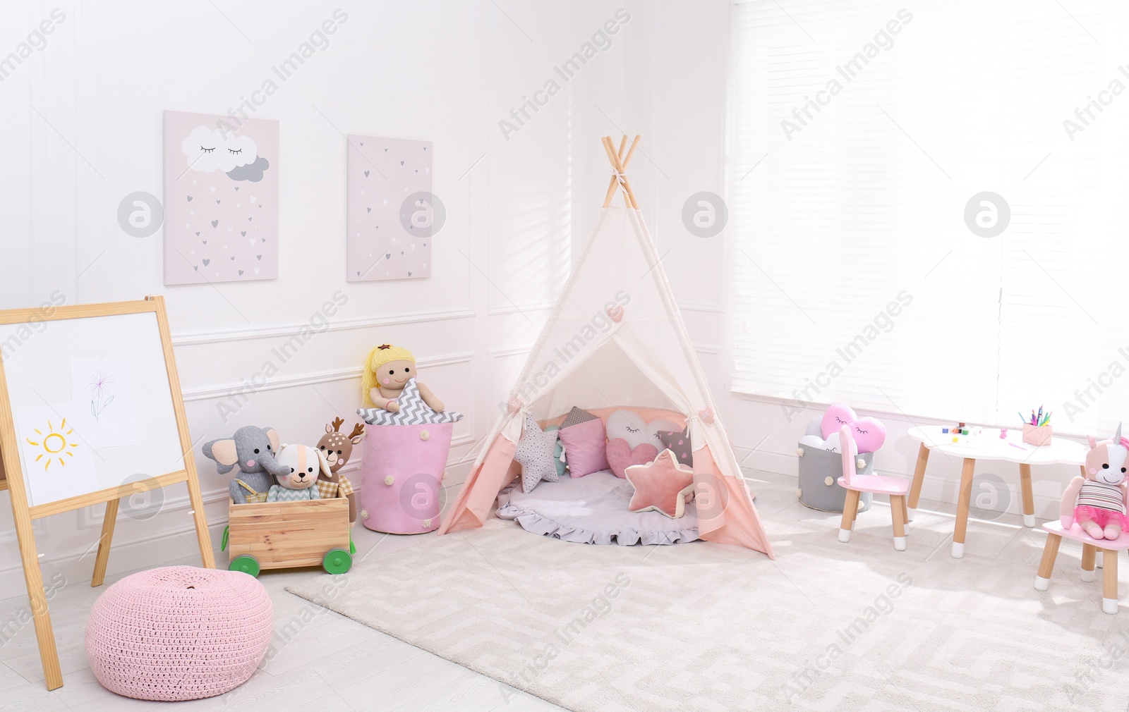 Photo of Cute child's room interior with toys, modern furniture and play tent