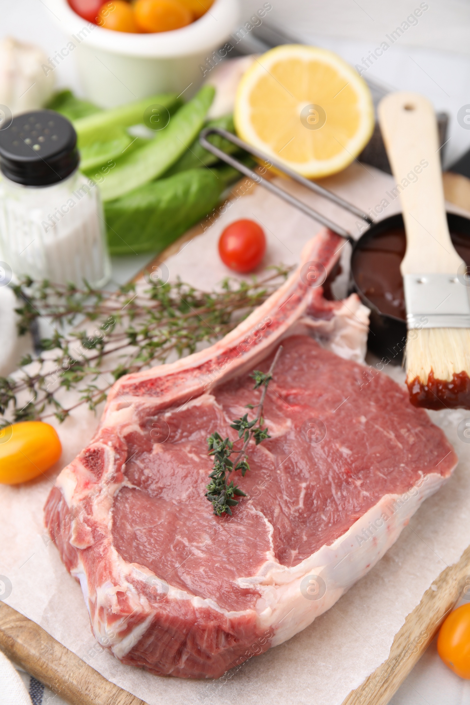 Photo of Raw meat, thyme and marinade on table, closeup