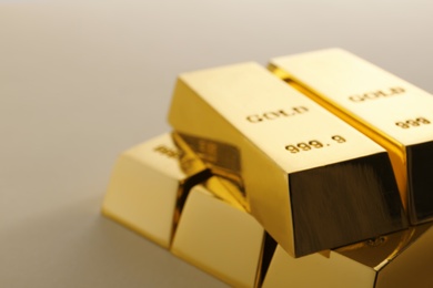 Photo of Precious shiny gold bars on light background