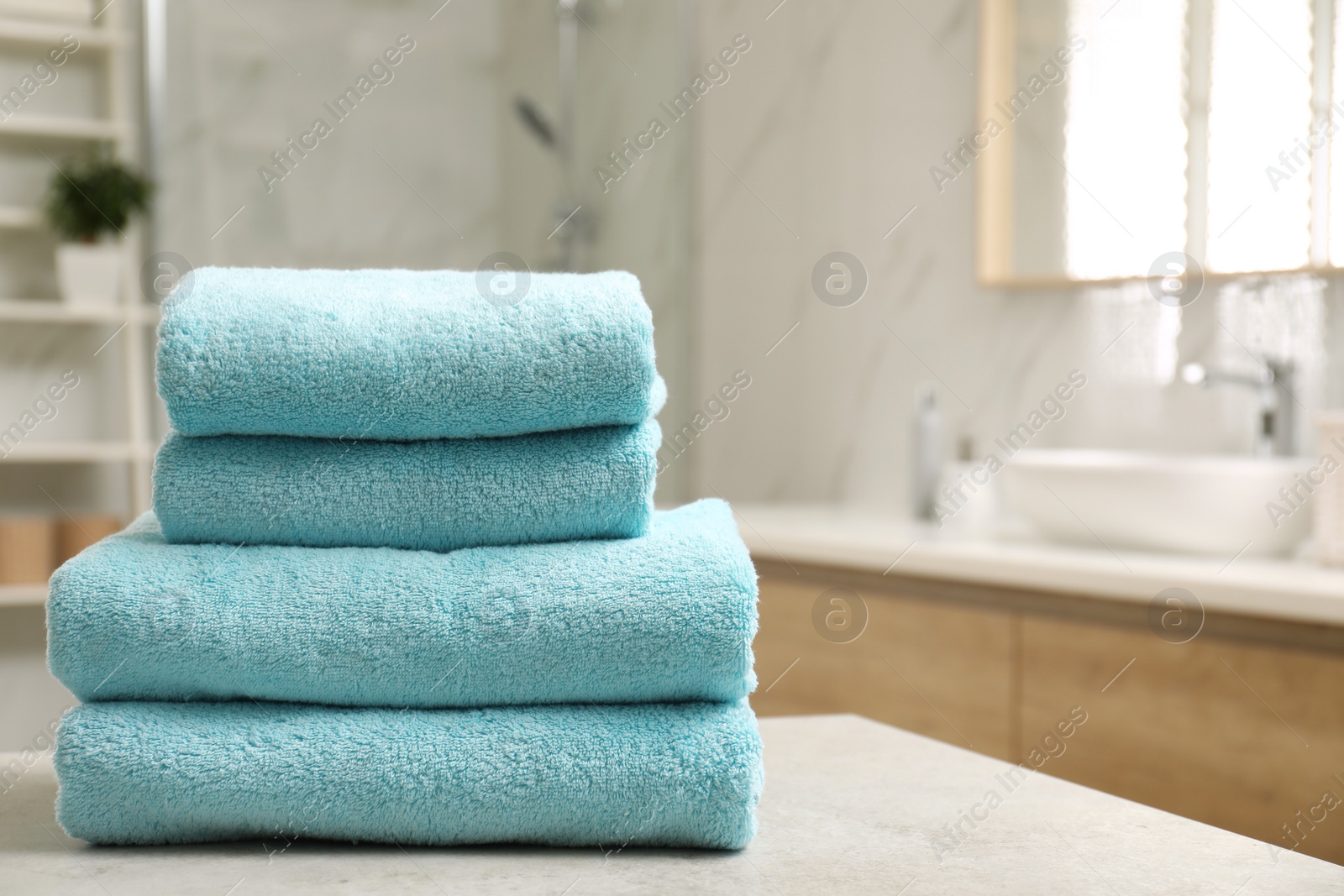 Photo of Stack of clean towels on table indoors. Space for text