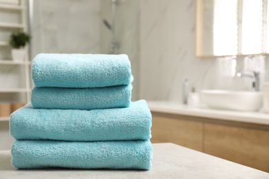 Photo of Stack of clean towels on table indoors. Space for text