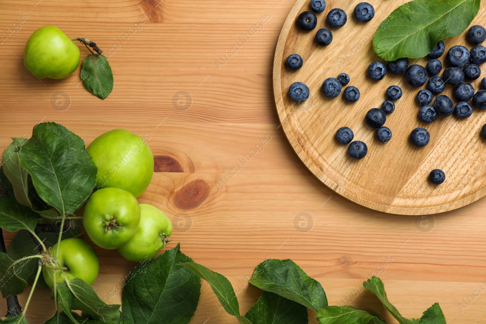 Photo of Flat lay composition with blueberries and green apples on wooden table