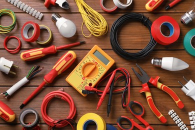 Flat lay composition with electrician's tools and accessories on wooden background