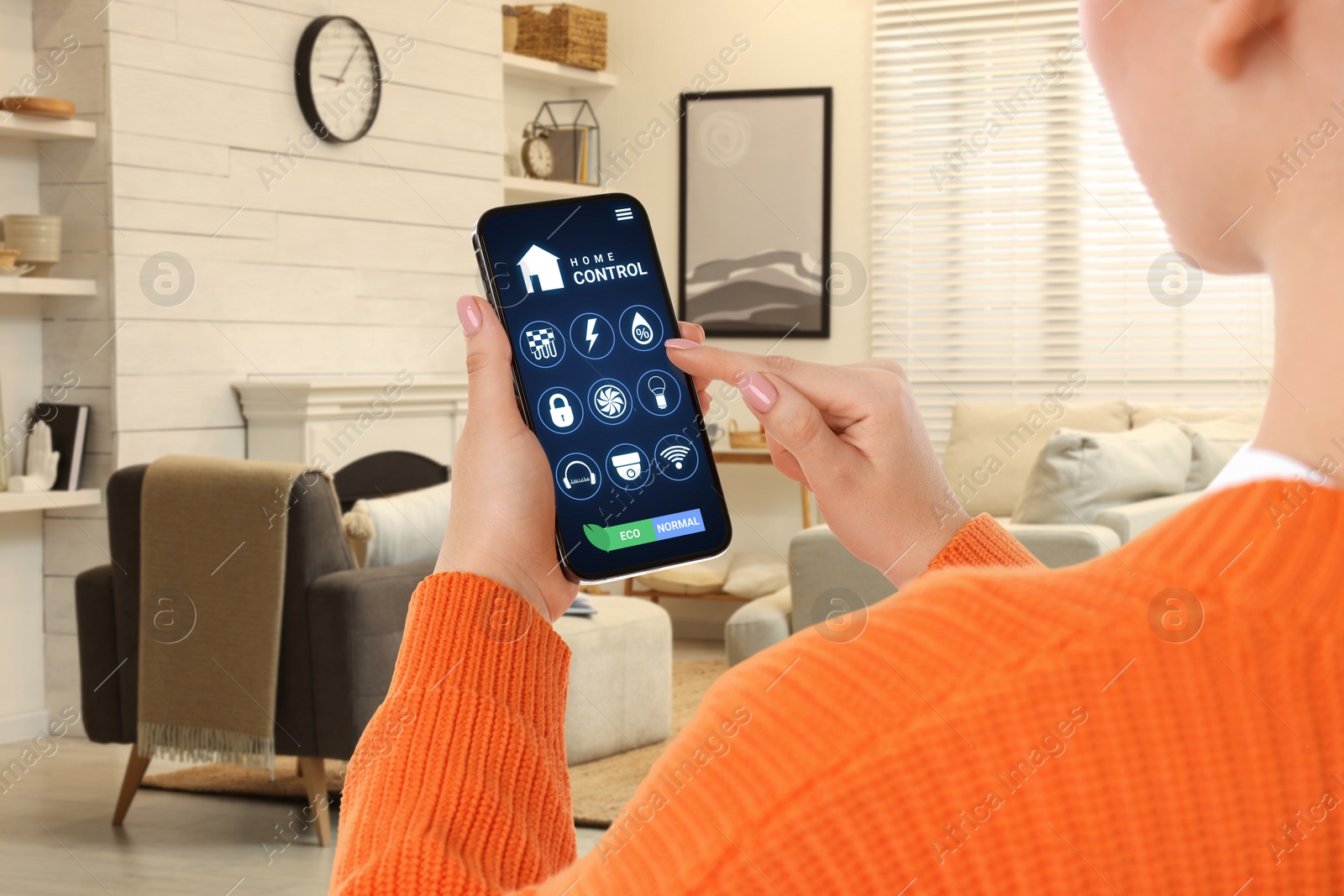 Image of Woman using smart home control system via application on mobile phone indoors, closeup