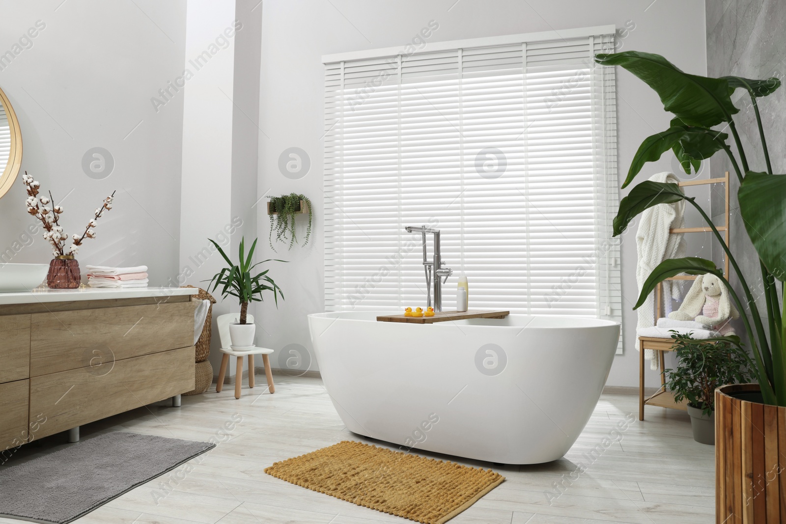 Photo of Stylish bathroom interior with beautiful tub and decor elements