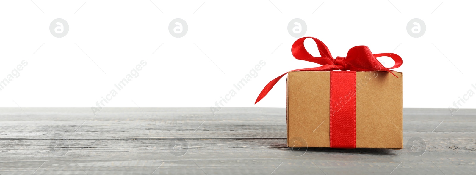 Photo of Christmas gift on grey wooden table against white background. Space for text