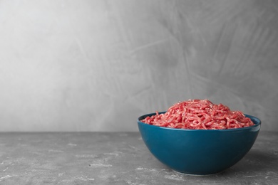 Photo of Fresh raw minced meat on grey table. Space for text