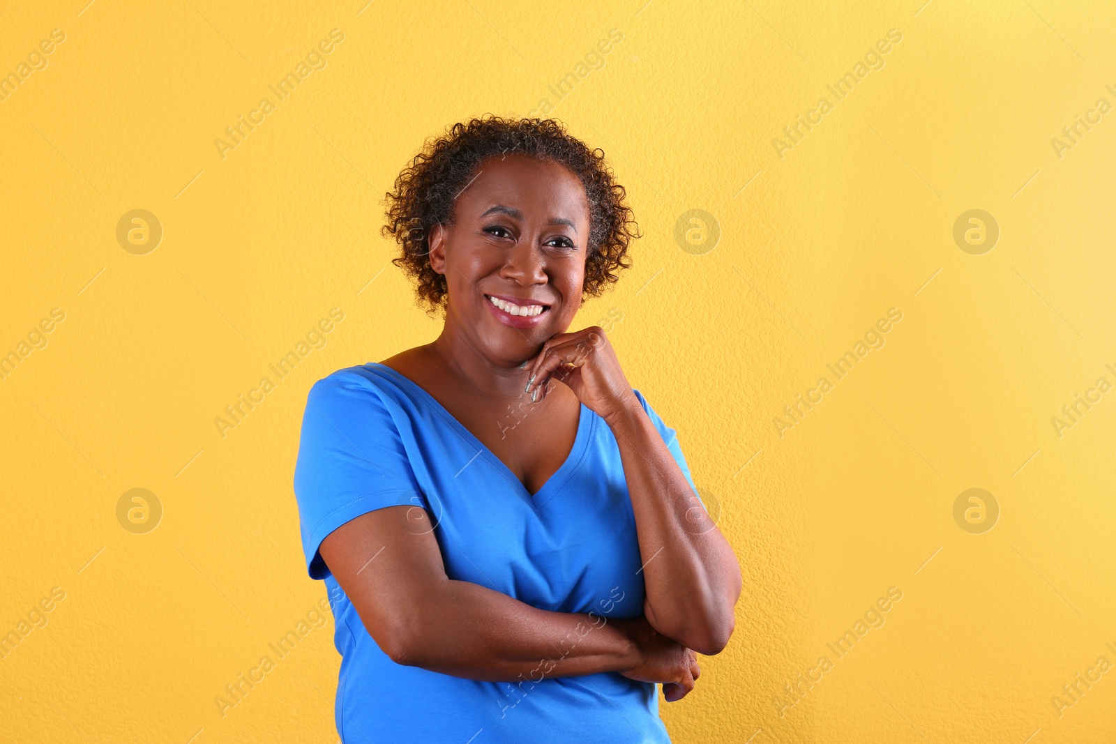 Photo of Portrait of happy African-American woman on yellow background