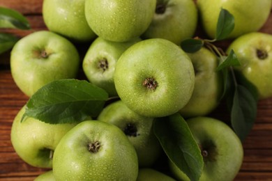 Photo of Fresh ripe green apples with water drops and leaves on wooden table, flat lay