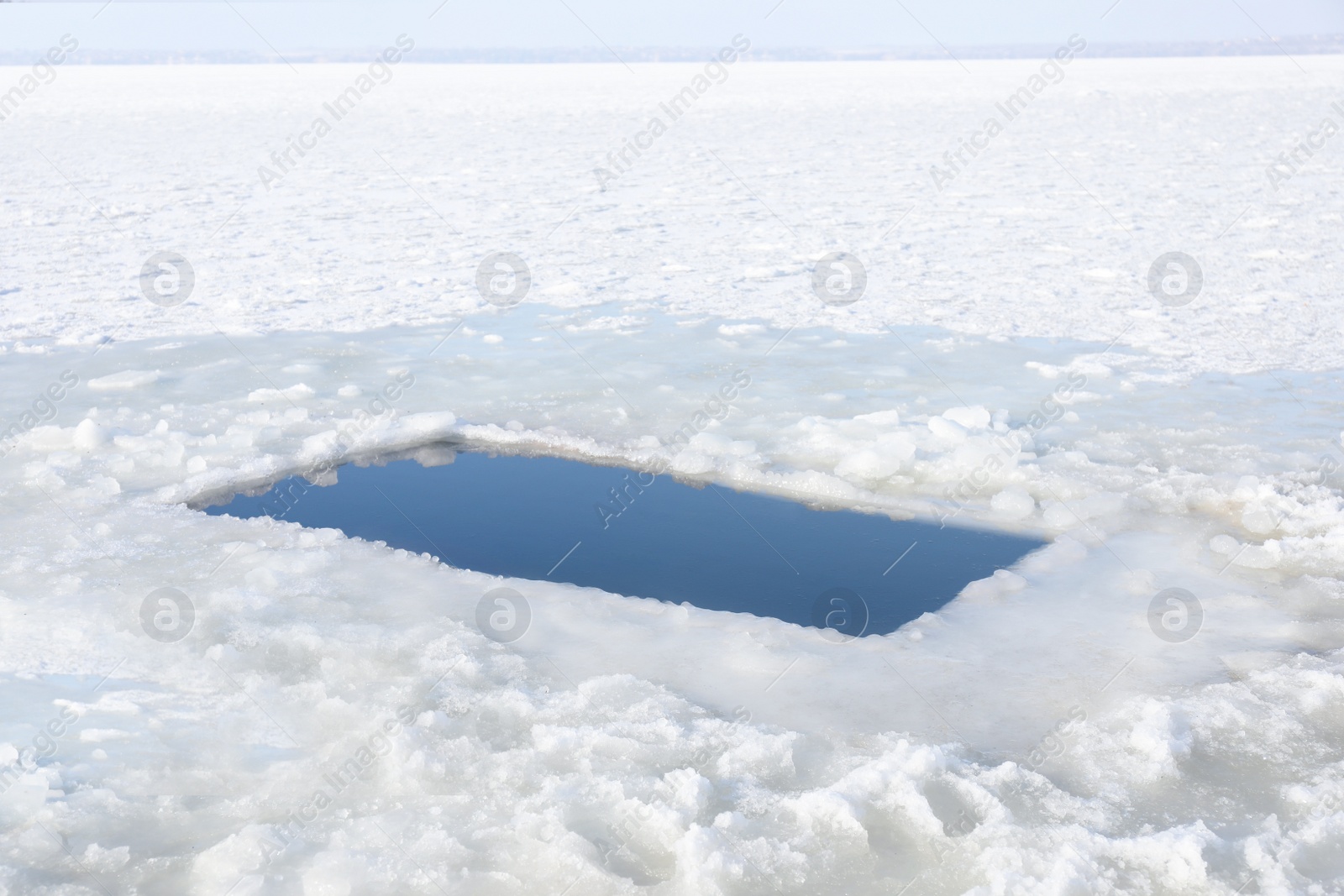 Photo of Ice hole in river on winter day. Baptism ritual