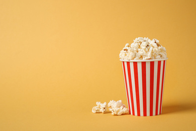 Photo of Delicious popcorn on yellow background. Space for text