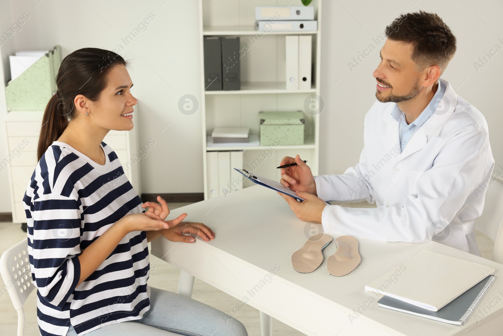 Photo of Handsome male orthopedist consulting patient in hospital