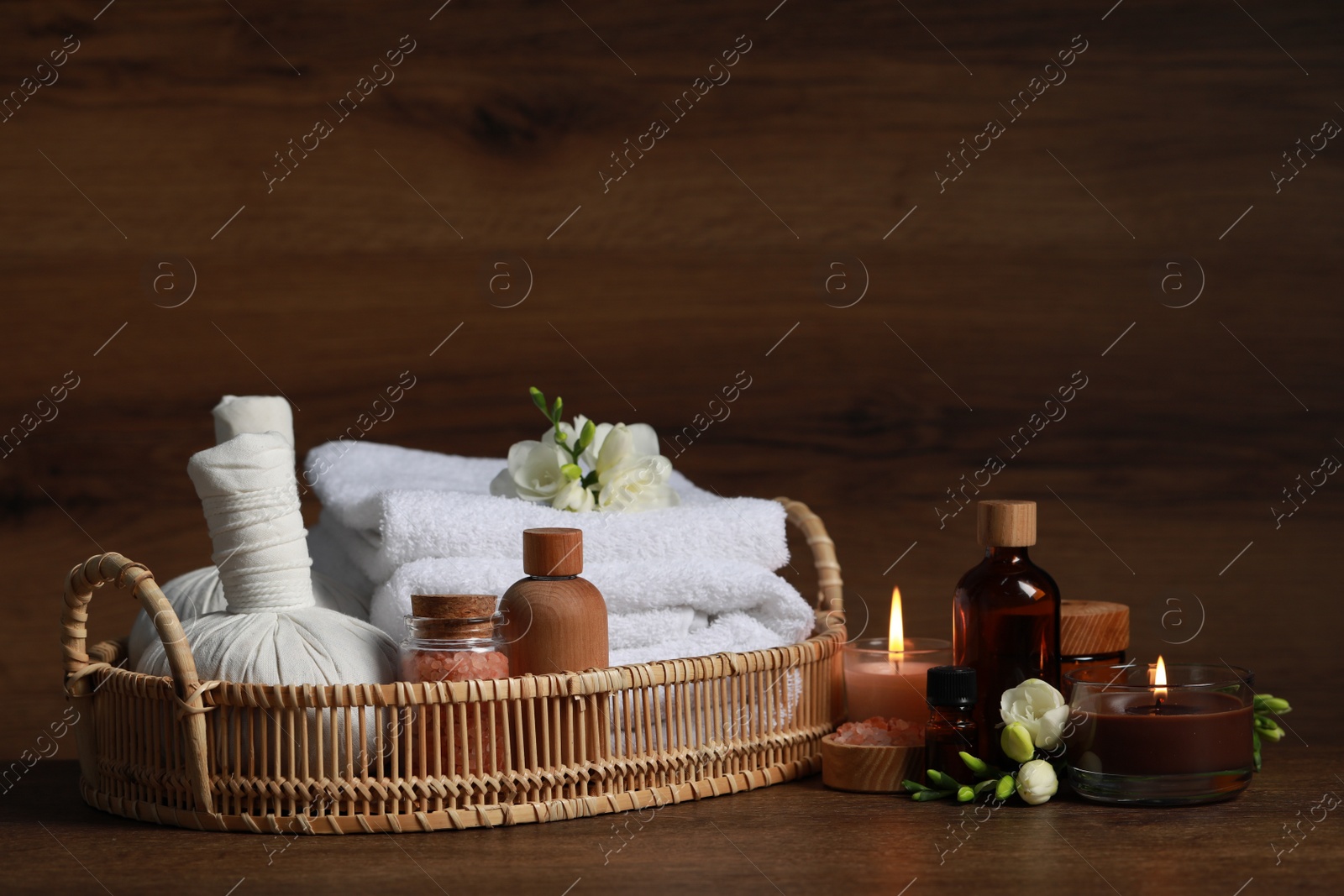 Photo of Beautiful composition with different spa products and burning candles on wooden table. Space for text