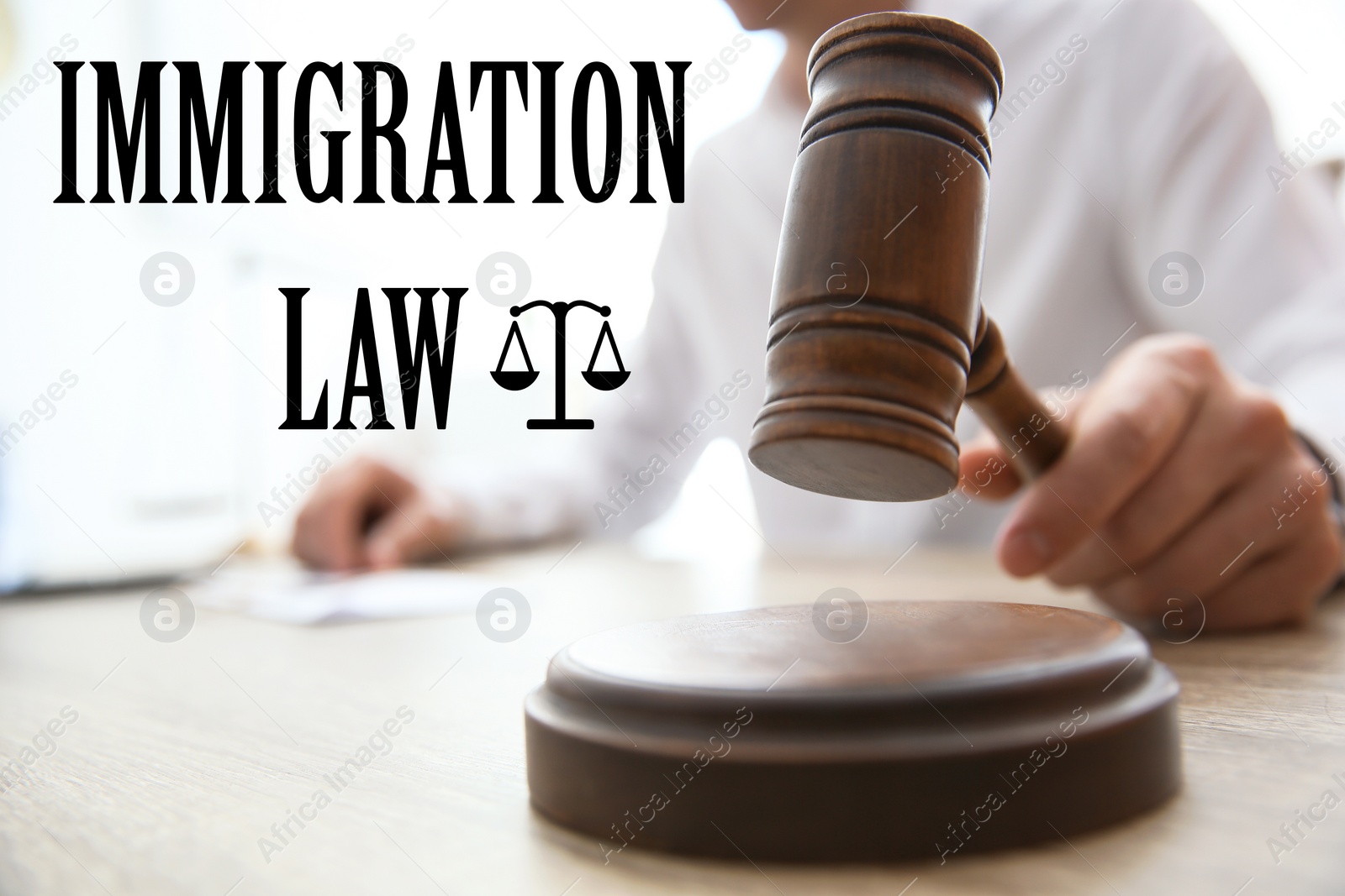 Image of Judge with gavel at table in courtroom, closeup. Immigration law concept