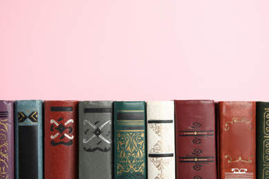 Photo of Collection of old books on pink background, space for text