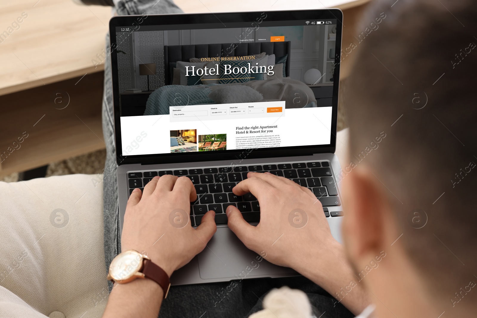 Image of Man using laptop to book hotel at home, closeup