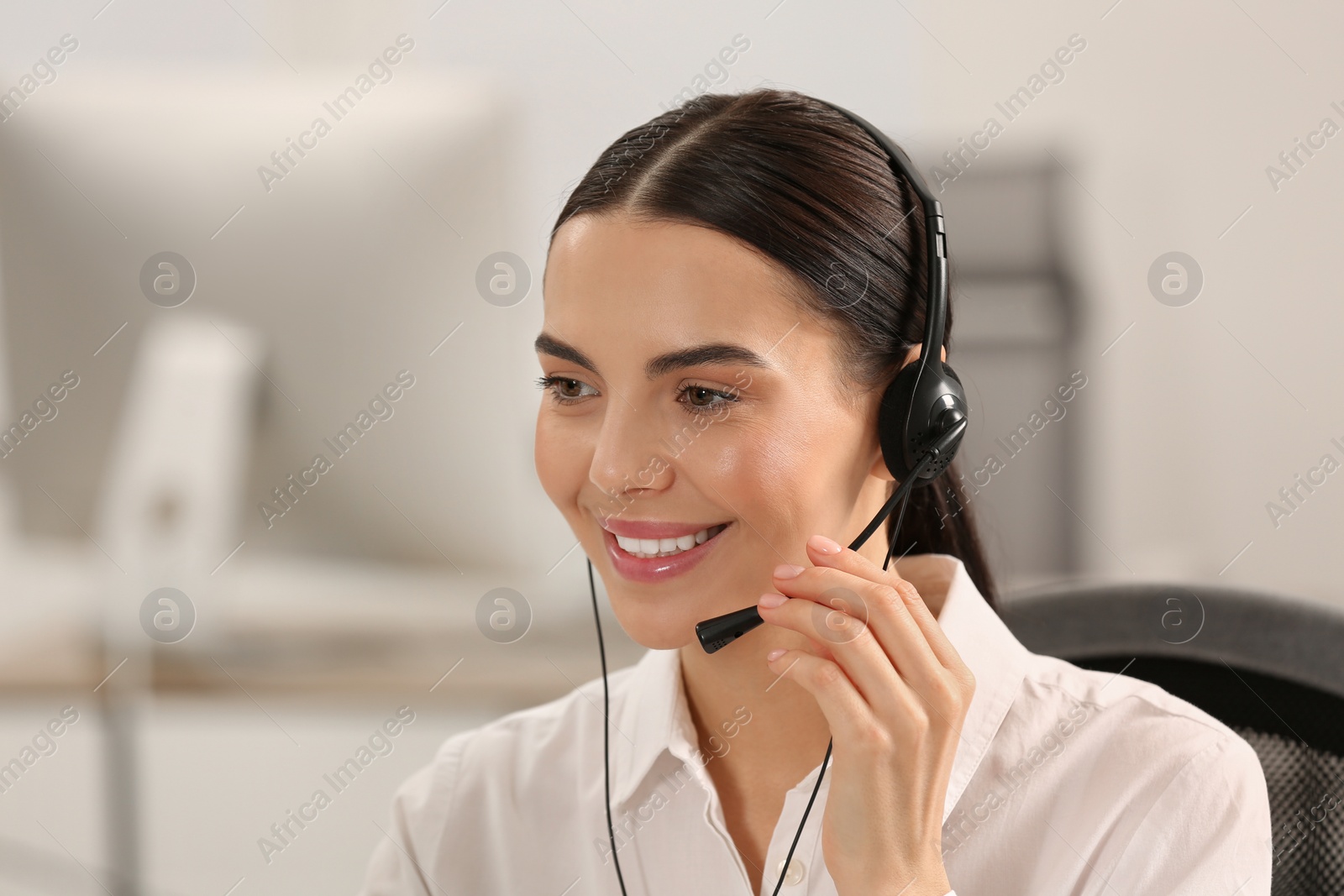 Photo of Hotline operator with headset working in office