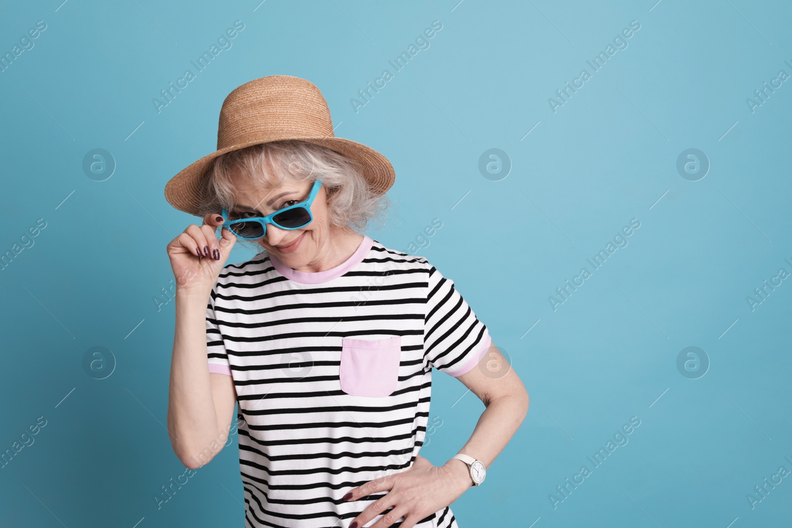 Photo of Portrait of mature woman in hipster outfit on color background. Space for text