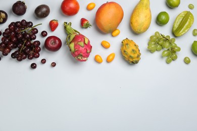 Photo of Many different delicious exotic fruits on light background, flat lay. Space for text