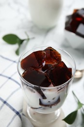 Photo of Glass of milk with delicious grass jelly on table, closeup