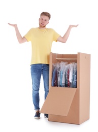 Photo of Young emotional man near wardrobe box on white background