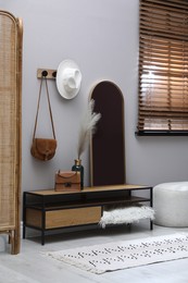 Stylish hallway interior with mirror and table near light wall