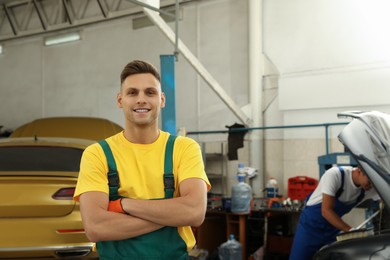 Photo of Portrait of professional mechanic at automobile repair shop