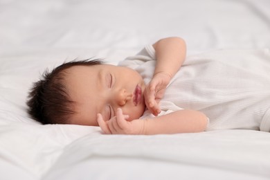 Cute newborn baby sleeping on white bed