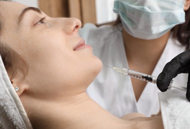 Cosmetologist giving facial injection to patient in clinic, closeup. Cosmetic surgery