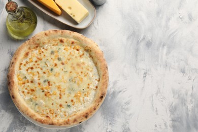 Delicious cheese pizza, oil and different kinds of cheese on light grey textured table, flat lay. Space for text